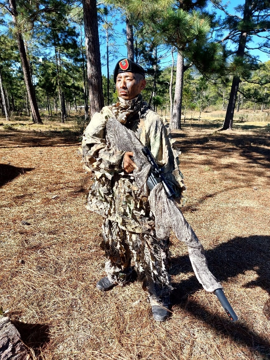 Mimetizado en la naturaleza, Shin Fujiyama pone en práctica técnicas de disparo durante operaciones anfibias en su tercer día de entrenamiento